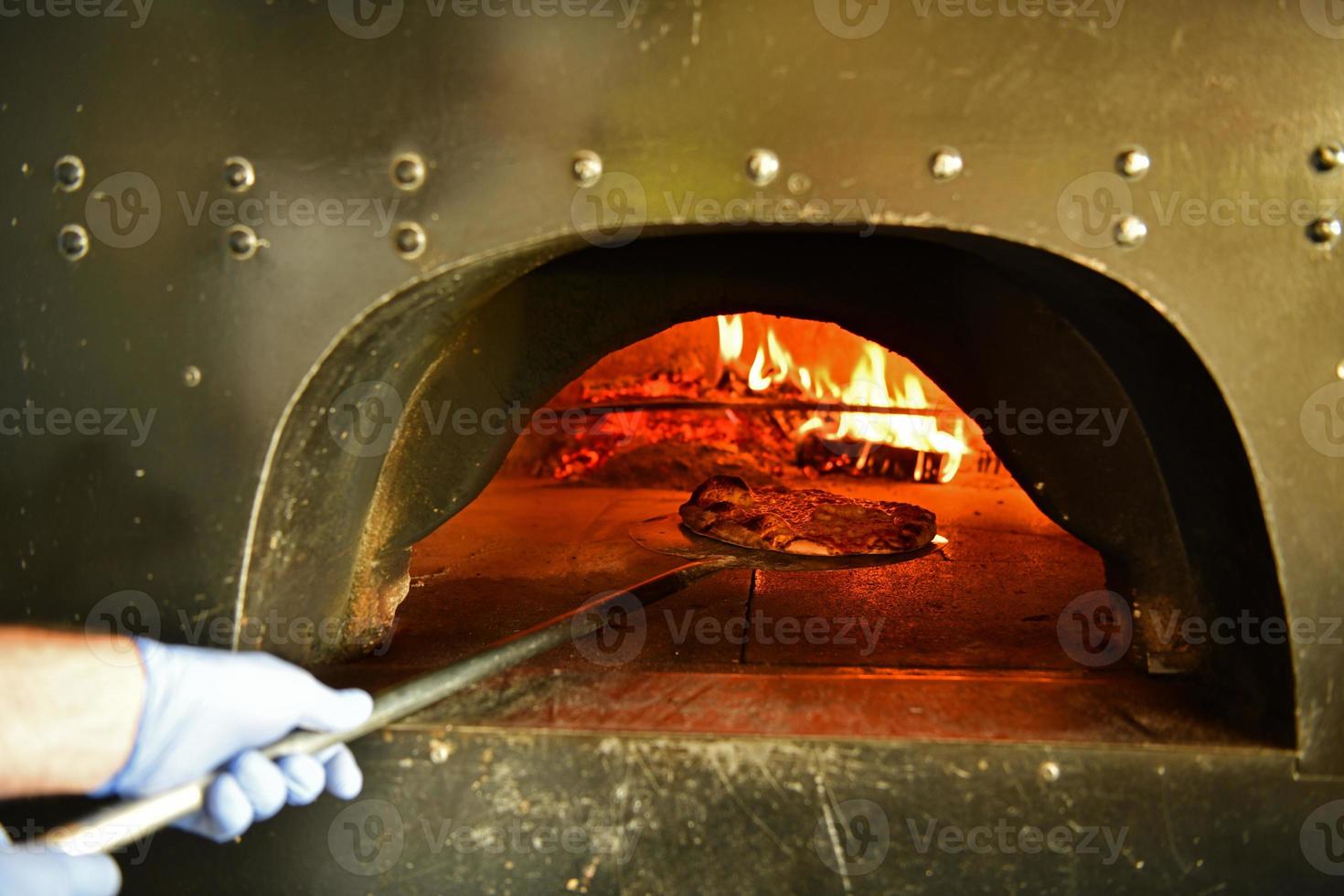 kock med skyddande coronavirus ansikte mask framställning pizza foto