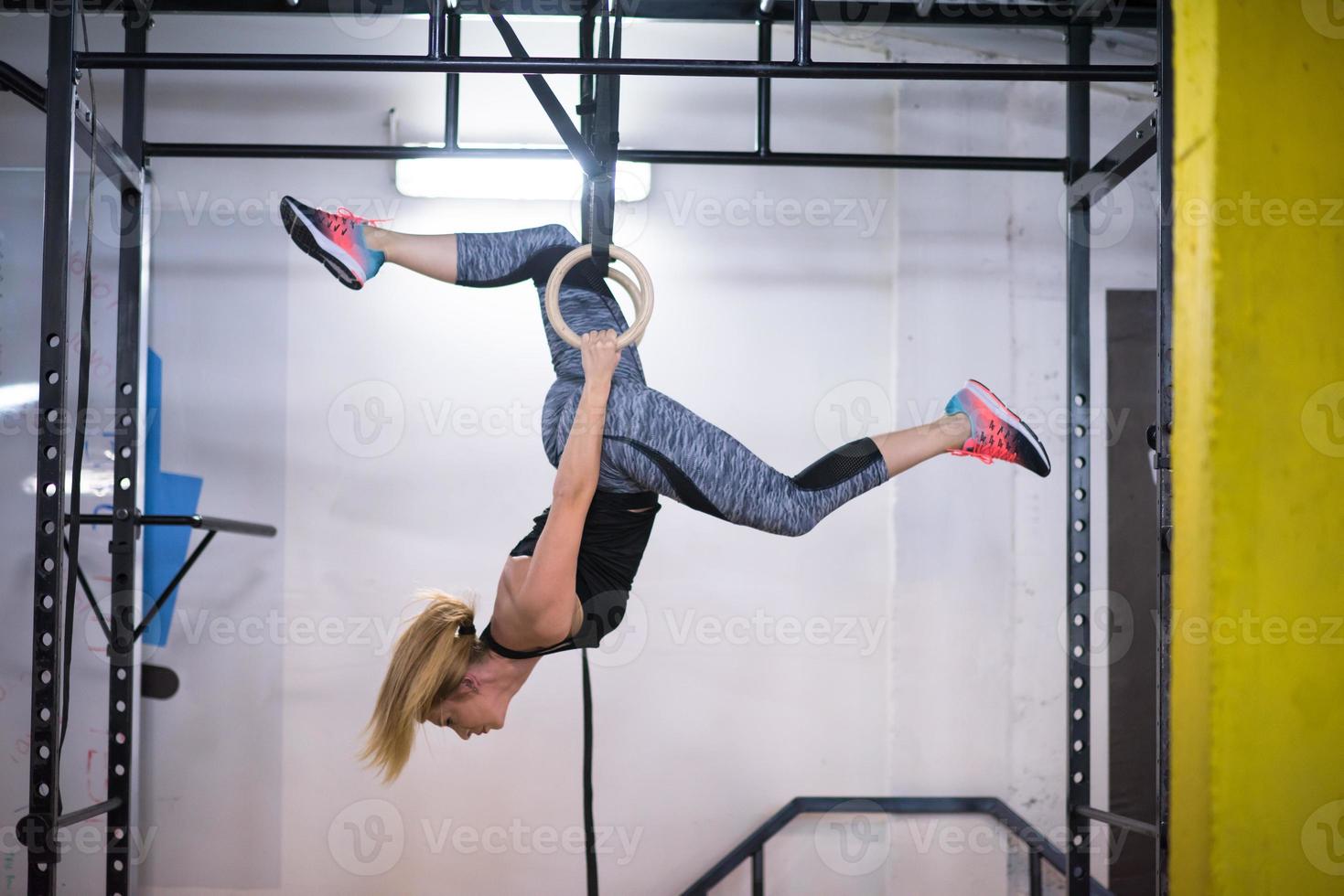 kvinna arbetssätt ut på gymnastiska ringar foto