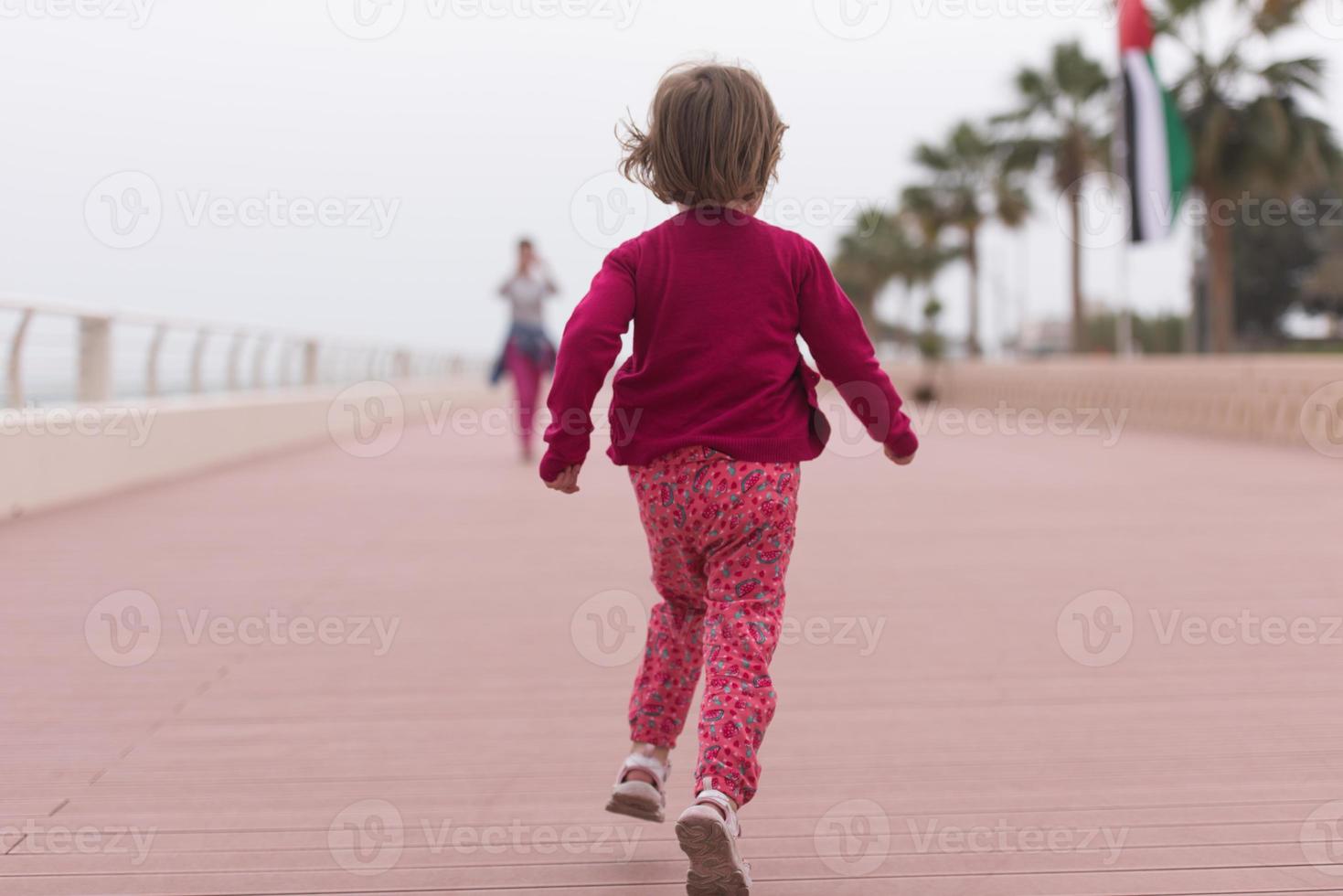 mor och söt liten flicka på de promenad förbi de hav foto