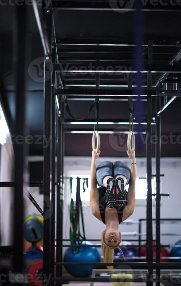 kvinna arbetssätt ut på gymnastiska ringar foto