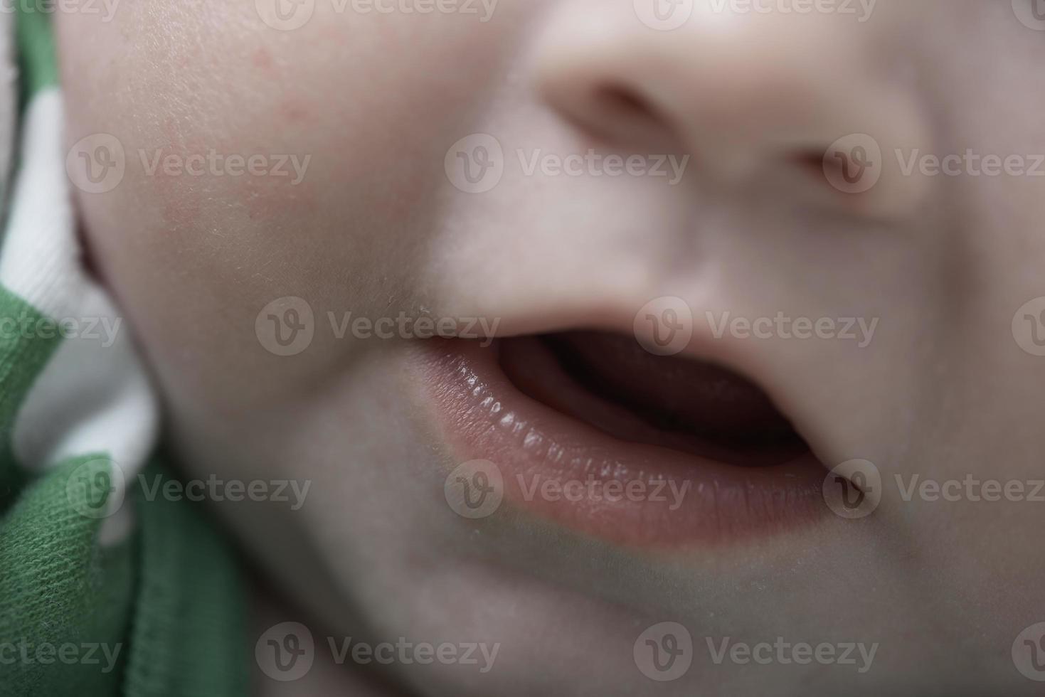 söt liten bebis spelar med händer och leende foto