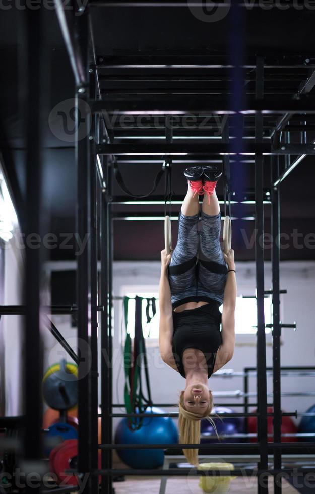 kvinna arbetssätt ut på gymnastiska ringar foto