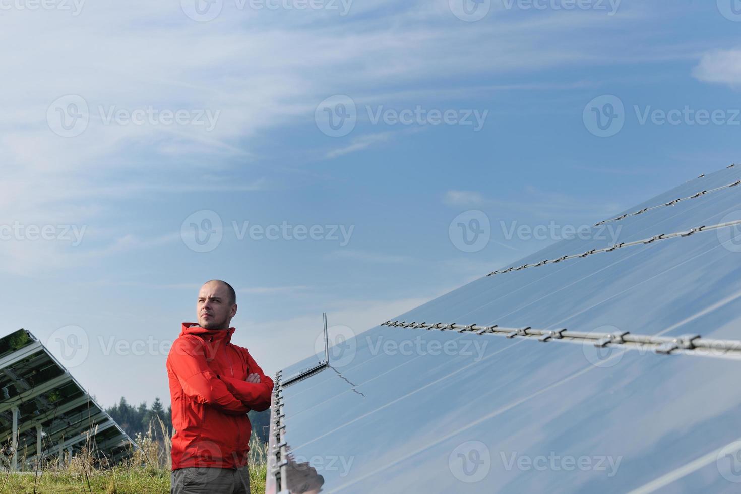 ingenjör använder sig av bärbar dator på sol- paneler växt fält foto