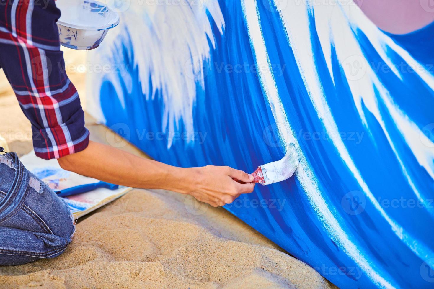 kvinnlig konstnär som arbetar på abstrakt akrylmålning, hand som håller pensel, stor duk utomhus foto