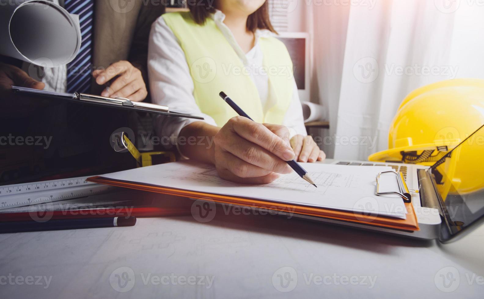 företag hand arbetssätt och bärbar dator med på på arkitektonisk projekt på konstruktion webbplats på kontor skrivbord i kontor foto