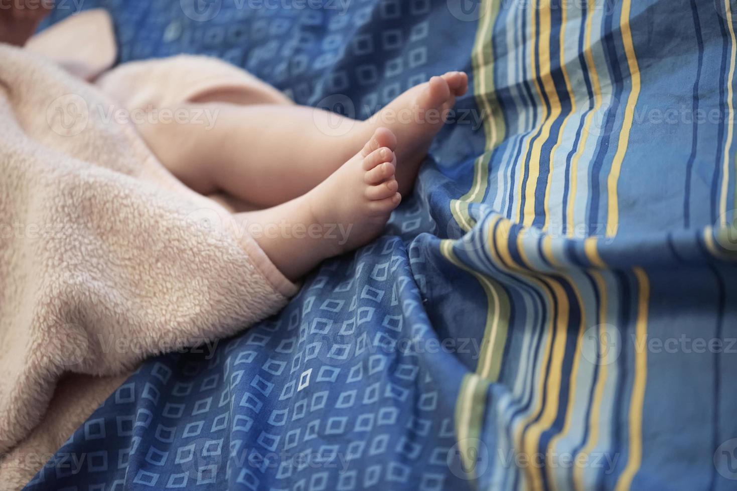 söt liten bebis spelar med händer och leende foto