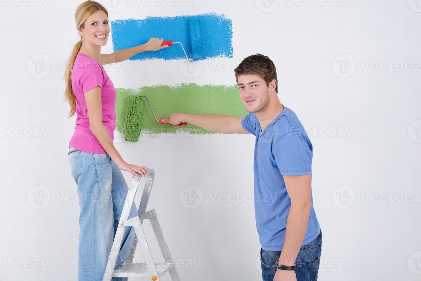 Lycklig par måla vägg på ny Hem foto