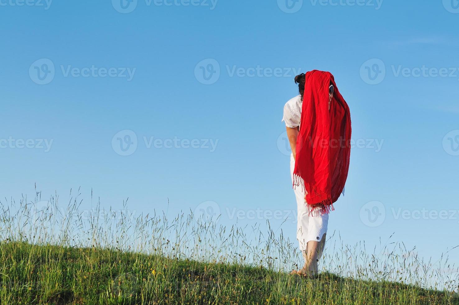 vacker kvinna med röd halsduk på ängen foto