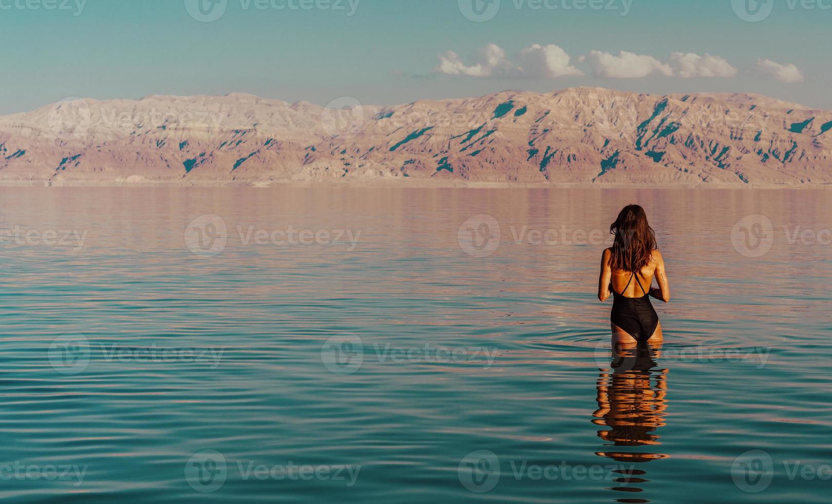 ung kvinna gående till död- hav, Israel foto