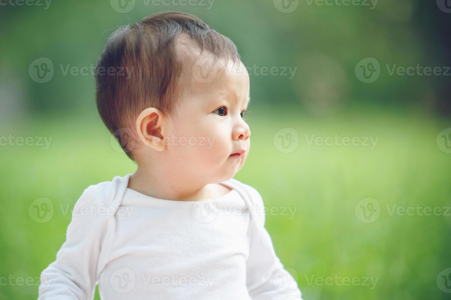 asiatisk bebis flicka leende i trädgård foto