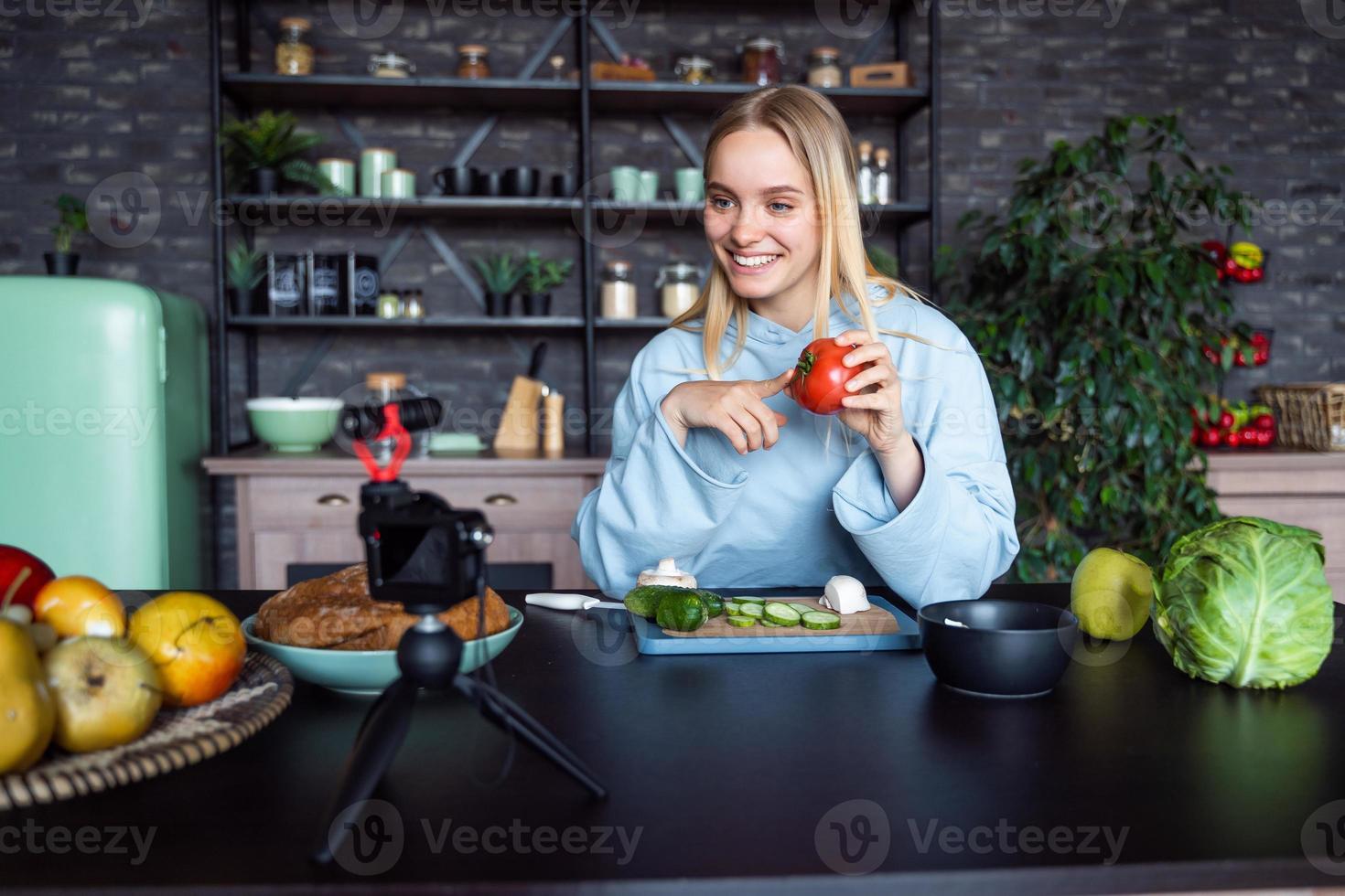 ung skön blond tar på videoklipp som hon kockar i de kök foto