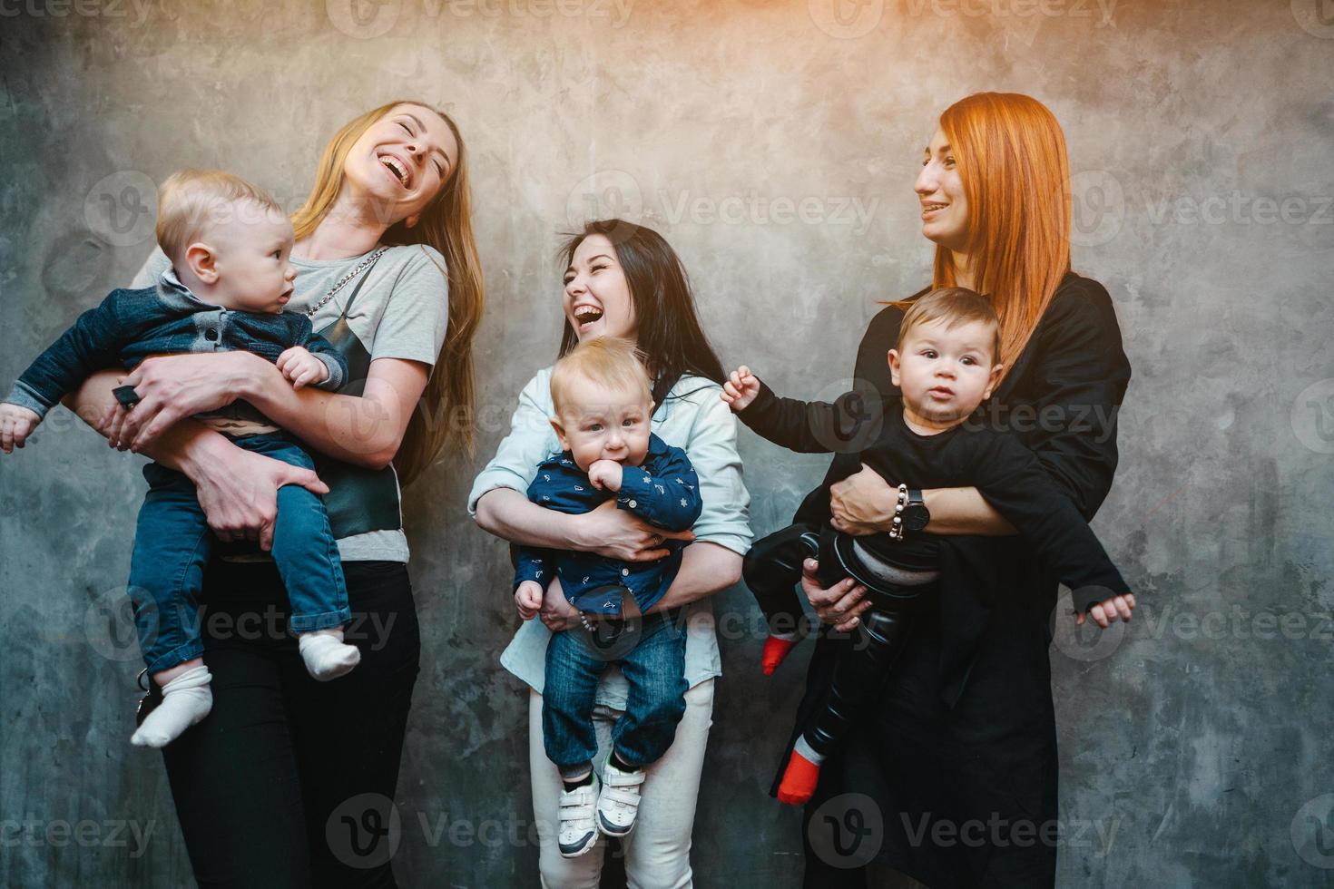 tre moms med deras barn Framställ på kamera foto