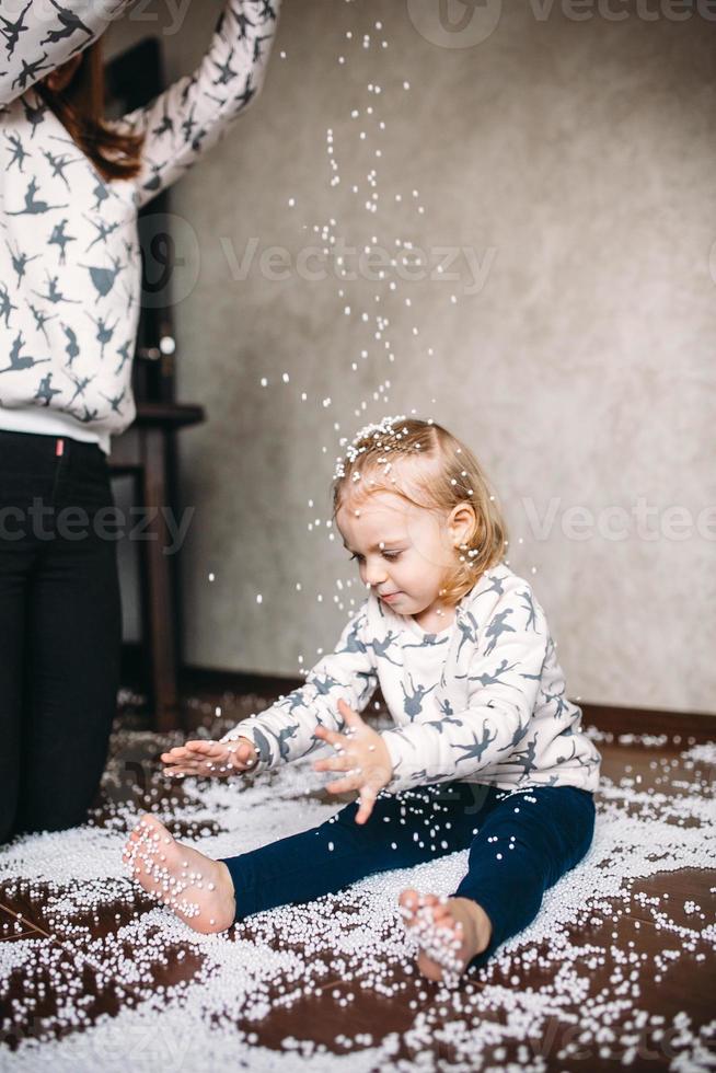 liten flicka är spelar med skum bollar foto