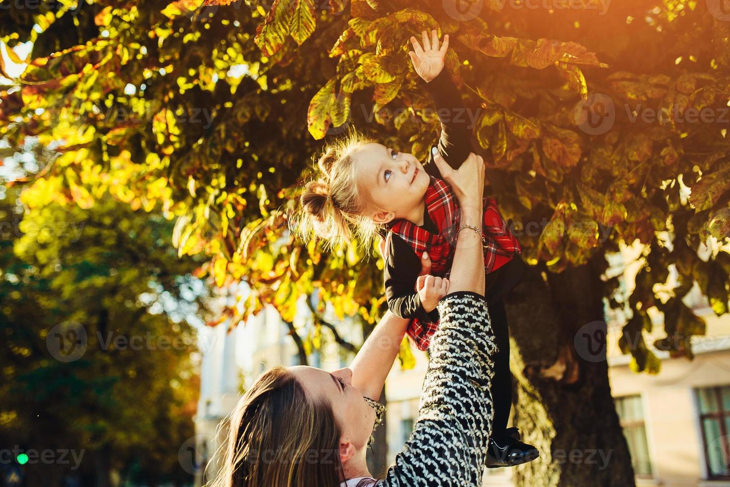 mor och liten dotter spelar i en parkera foto