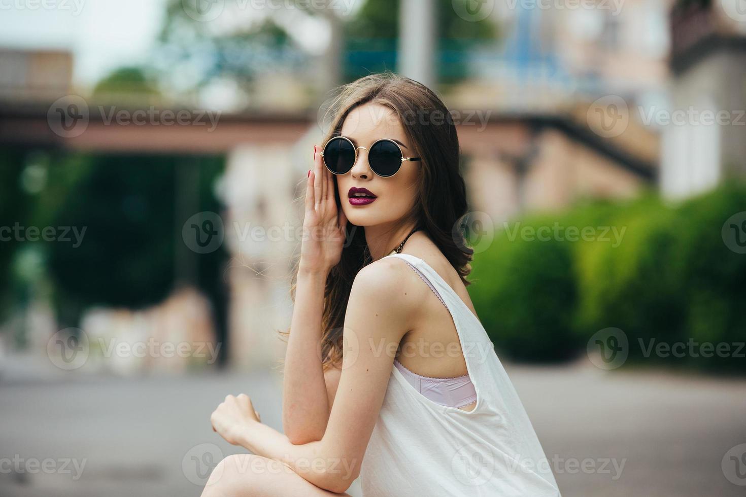 vacker flicka i solglasögon sitter foto