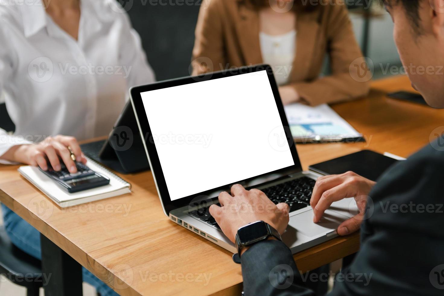 människor använder sig av och ser på attrapp bärbar dator dator på trä- tabell tillsammans på kontor skrivbord med läsplatta foto