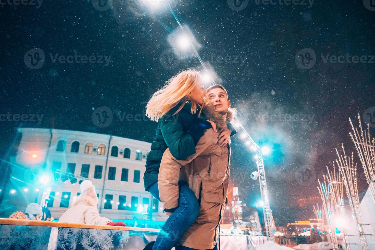 glad och lekfull par i värma vinter- klädespersedlar är lurar runt om foto