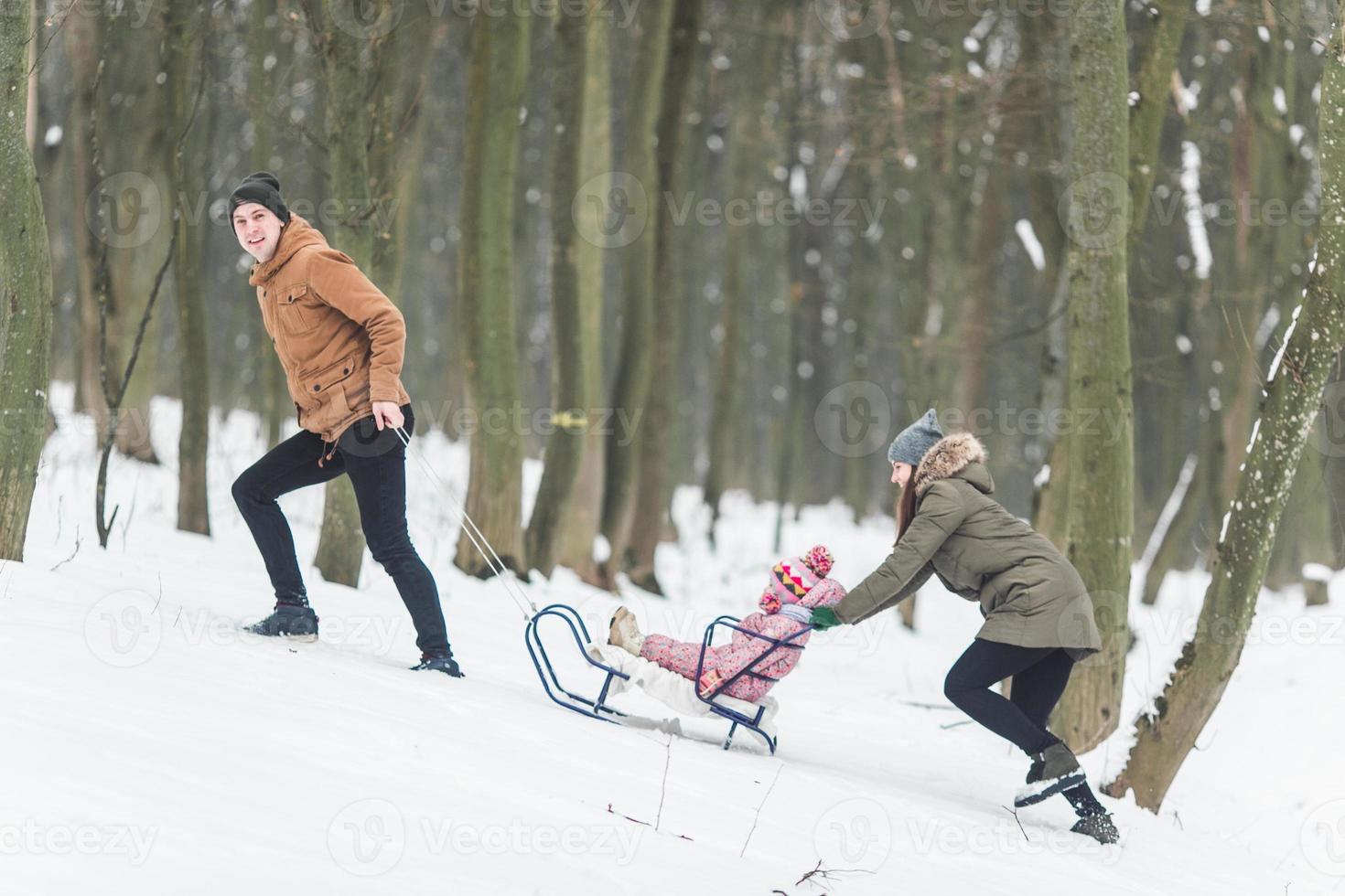 pappa och mamma med en liten dotter i de parkera foto