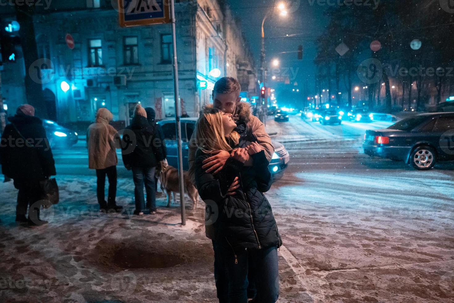 ung vuxen par gående på snö täckt trottoar foto