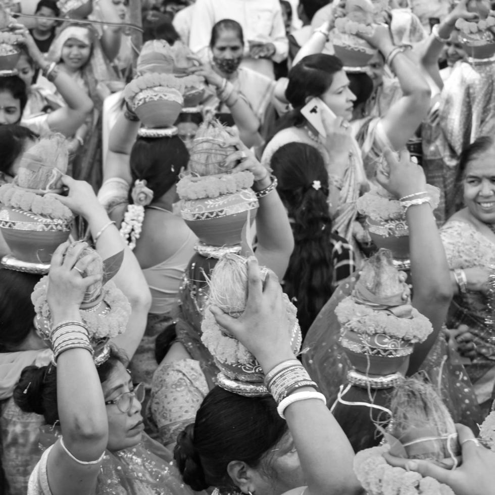 delhi, Indien april 03 2022 - kvinnor med kalash på huvud under jagannath tempel mangal kalash yatra, indisk hindu anhängare bära lergods kastruller som innehåller helig vatten med kokos på topp-svart och vit foto