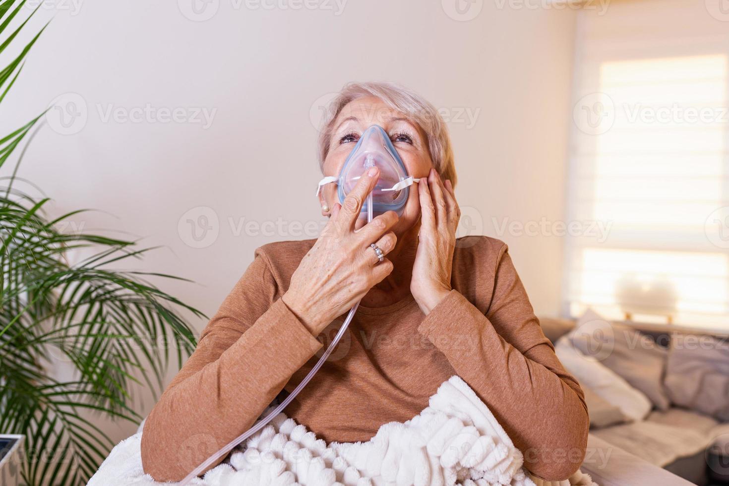 sjuk äldre kvinna framställning inandning, medicin är de bäst medicin. sjuk senior kvinna bär ett syre mask och genomgå behandling. senior kvinna med ett inhalator foto