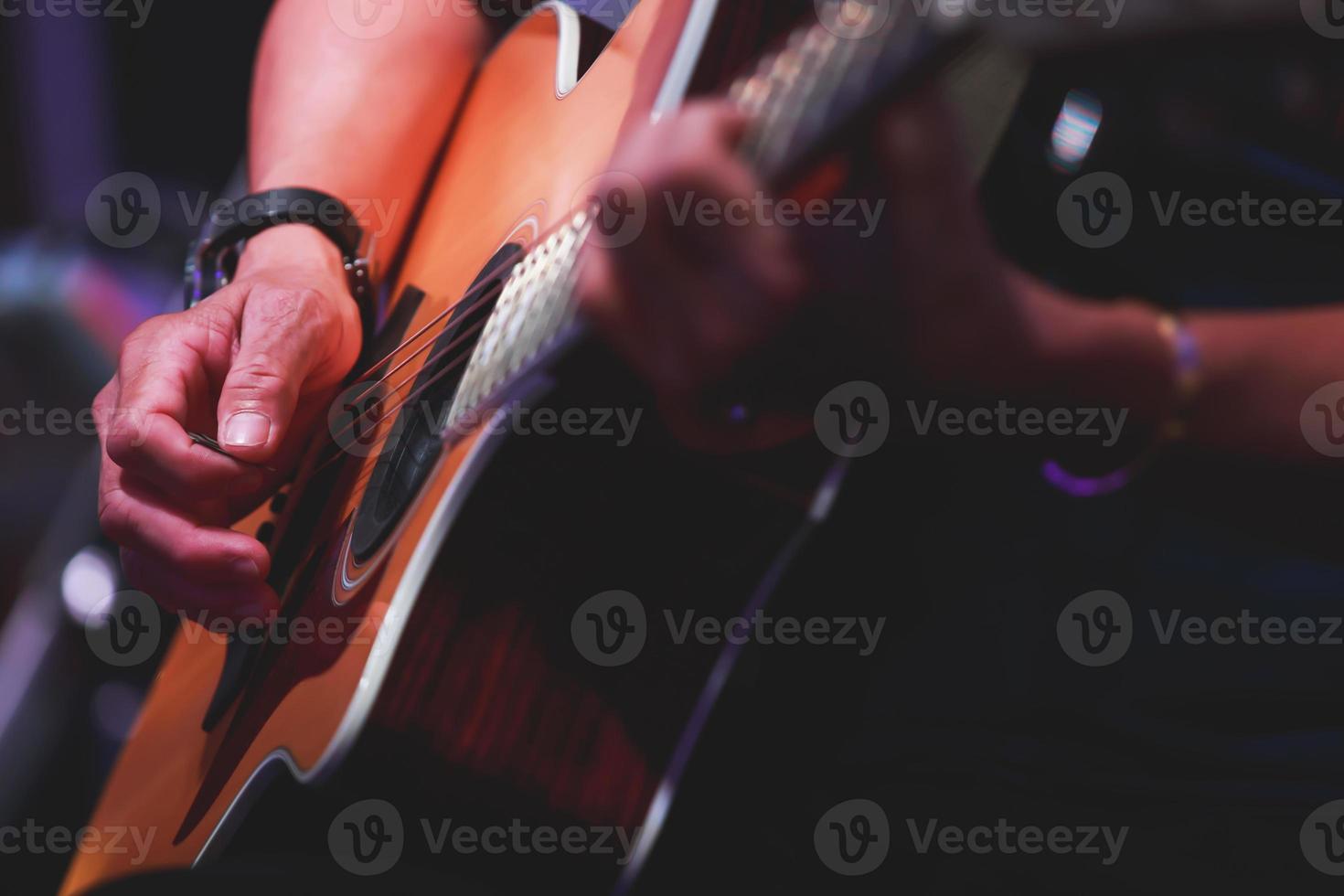 stänga upp av man händer spelar på akustisk gitarr. foto