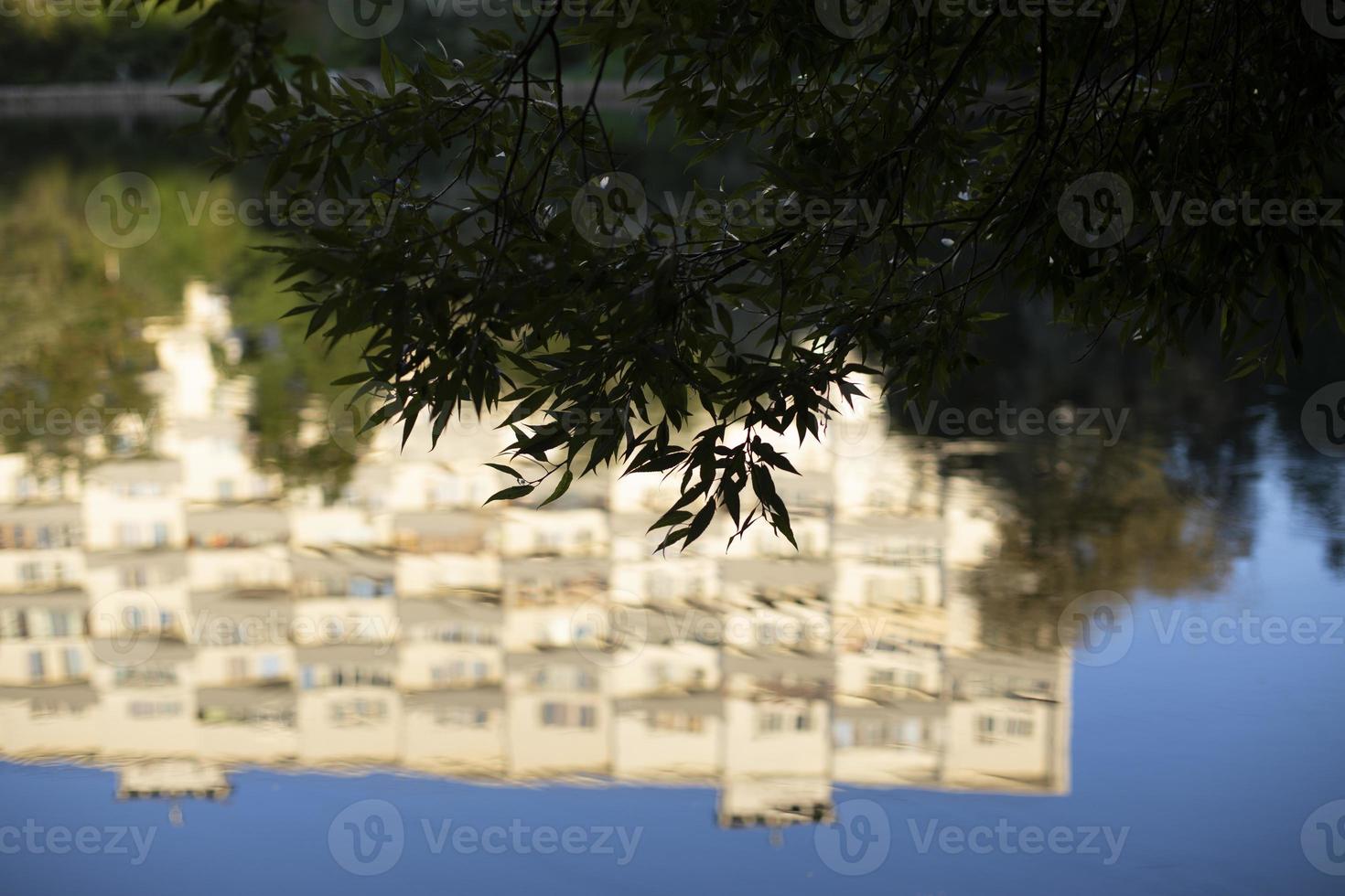 de byggnad är reflekterad i de vatten. de yta av de sjö i de parkera. de vit byggnad är reflekterad som i en spegel. foto