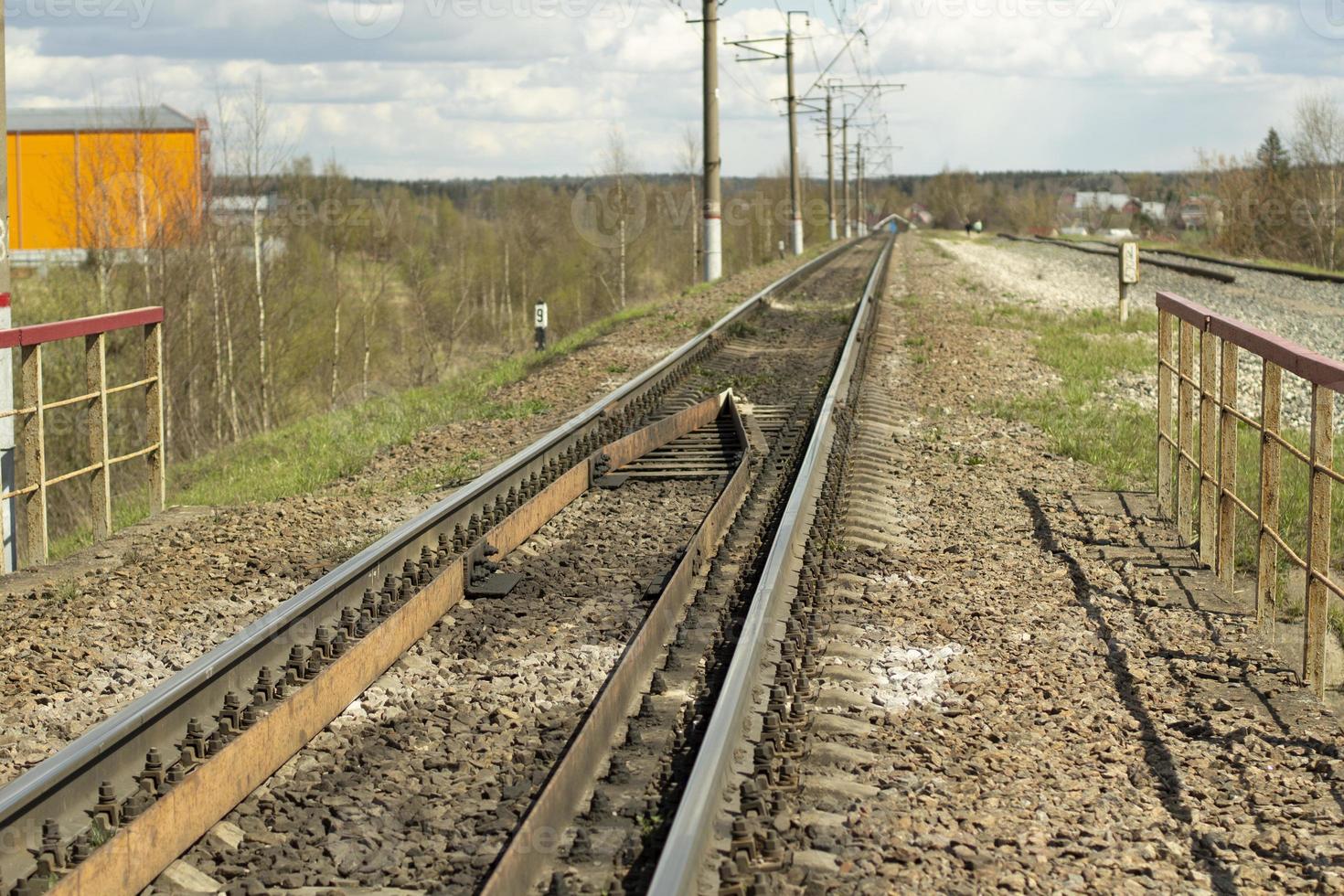 de järnväg är ett körfält. de linje konvergerar i de distans. de väg för de rörelse av de tåg. skenor och sliprar. foto
