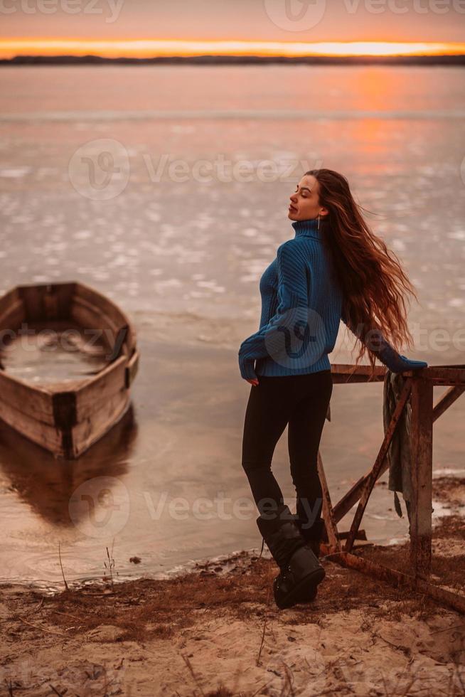 kvinna njuter tid avkopplande förbi de skön sjö på soluppgång. foto