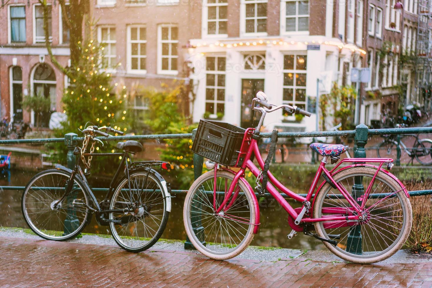 cyklar foder en bro över de kanaler av amsterdam foto
