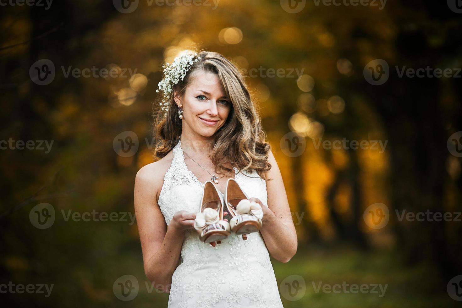 brud innehav bröllop skor foto