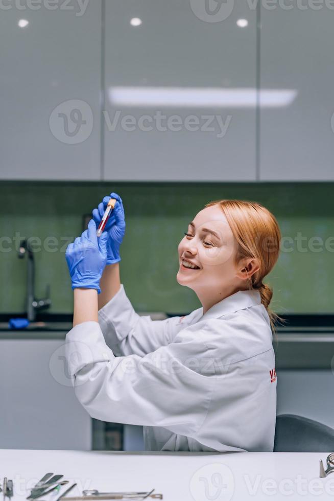 kvinna medicinsk eller vetenskaplig forskare ser på en testa rör i en laboratorium. foto