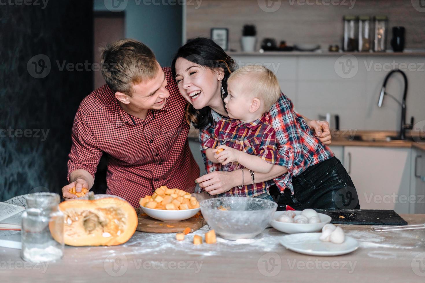 pappa, mamma och liten son laga mat en paj foto