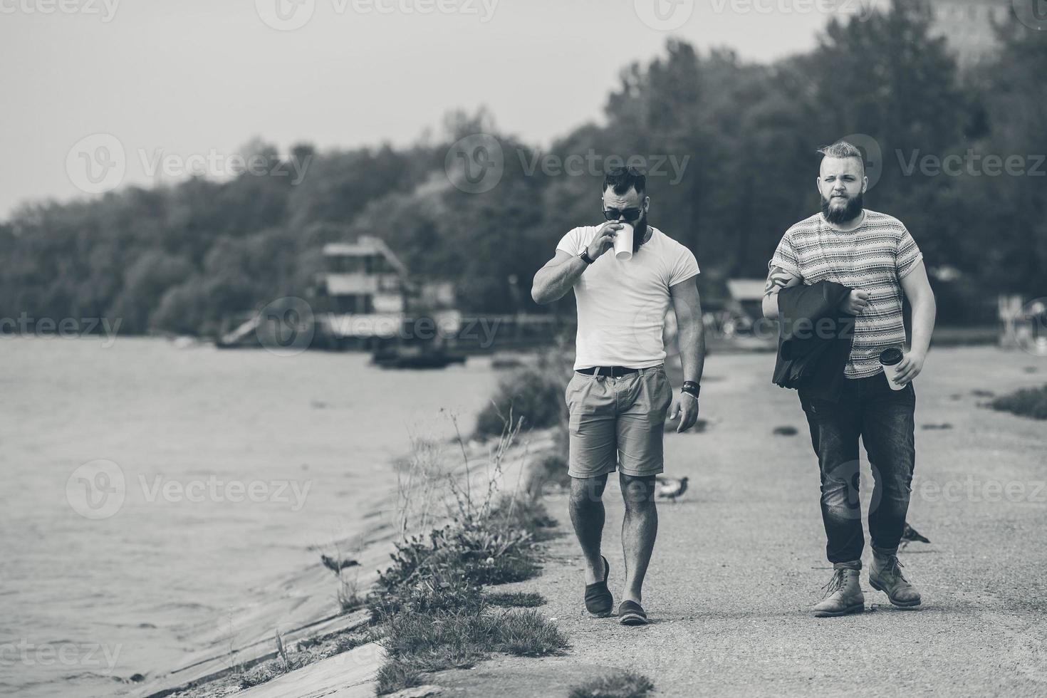 två män promenad och dryck kaffe foto