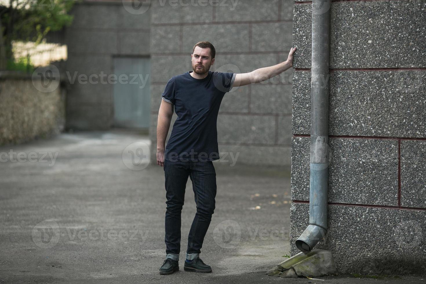 mannen i de autentiska stövlarna och på jeans i en gammal stad foto