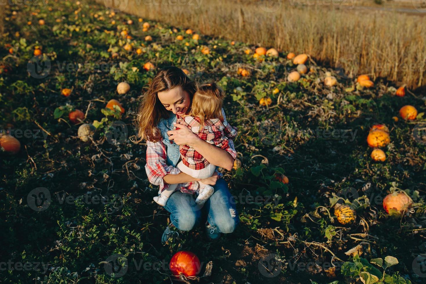 mor och dotter på en fält med pumpor foto