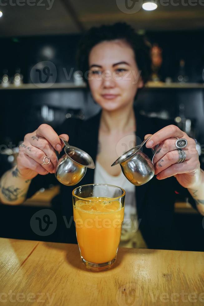 kiev, ukraina - april 14, 2019 en flicka gör en orange kaffe cocktail foto