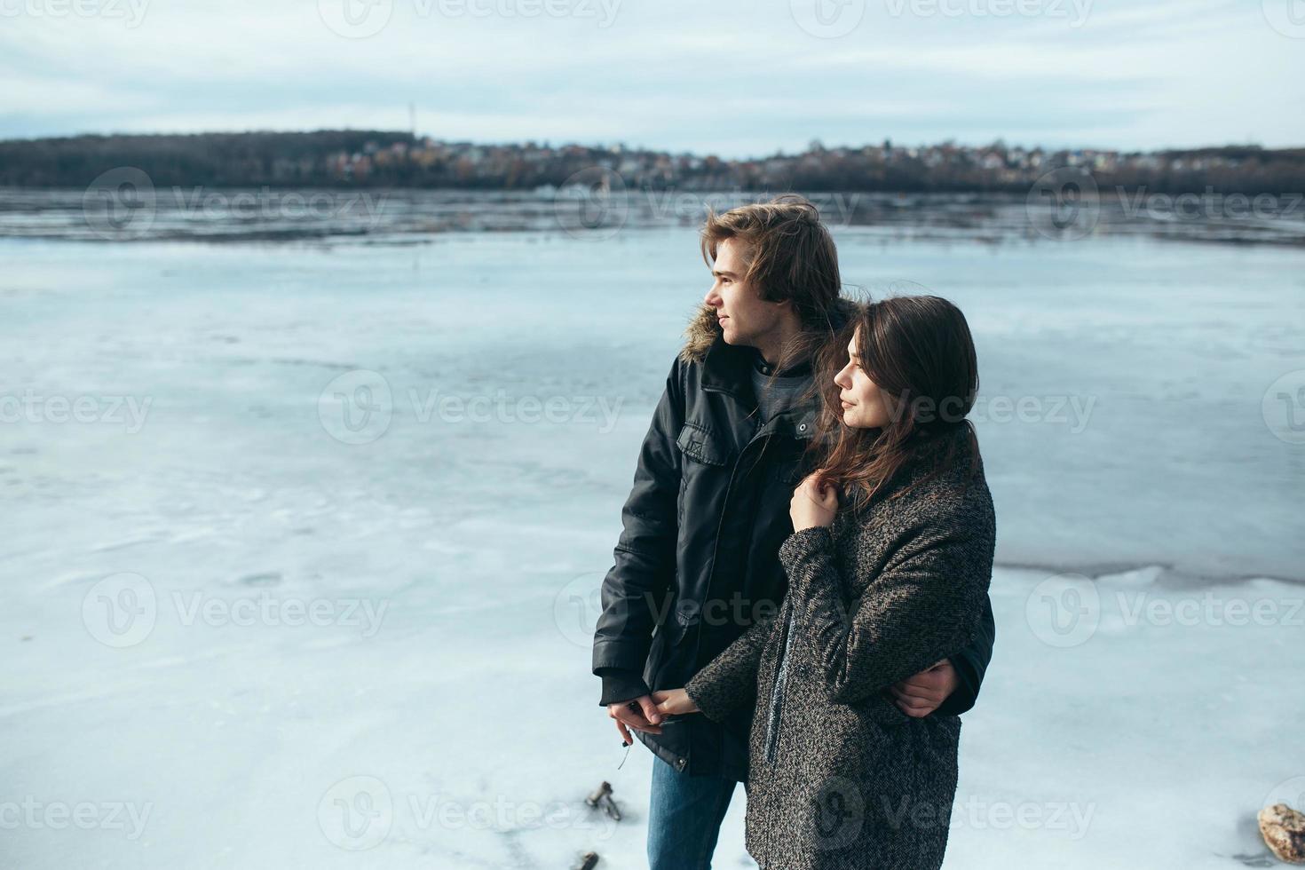 ung skön par på de is av en frysta sjö foto