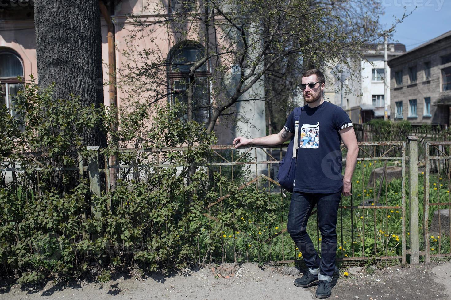 mannen i de autentiska stövlarna och på jeans i en gammal stad foto