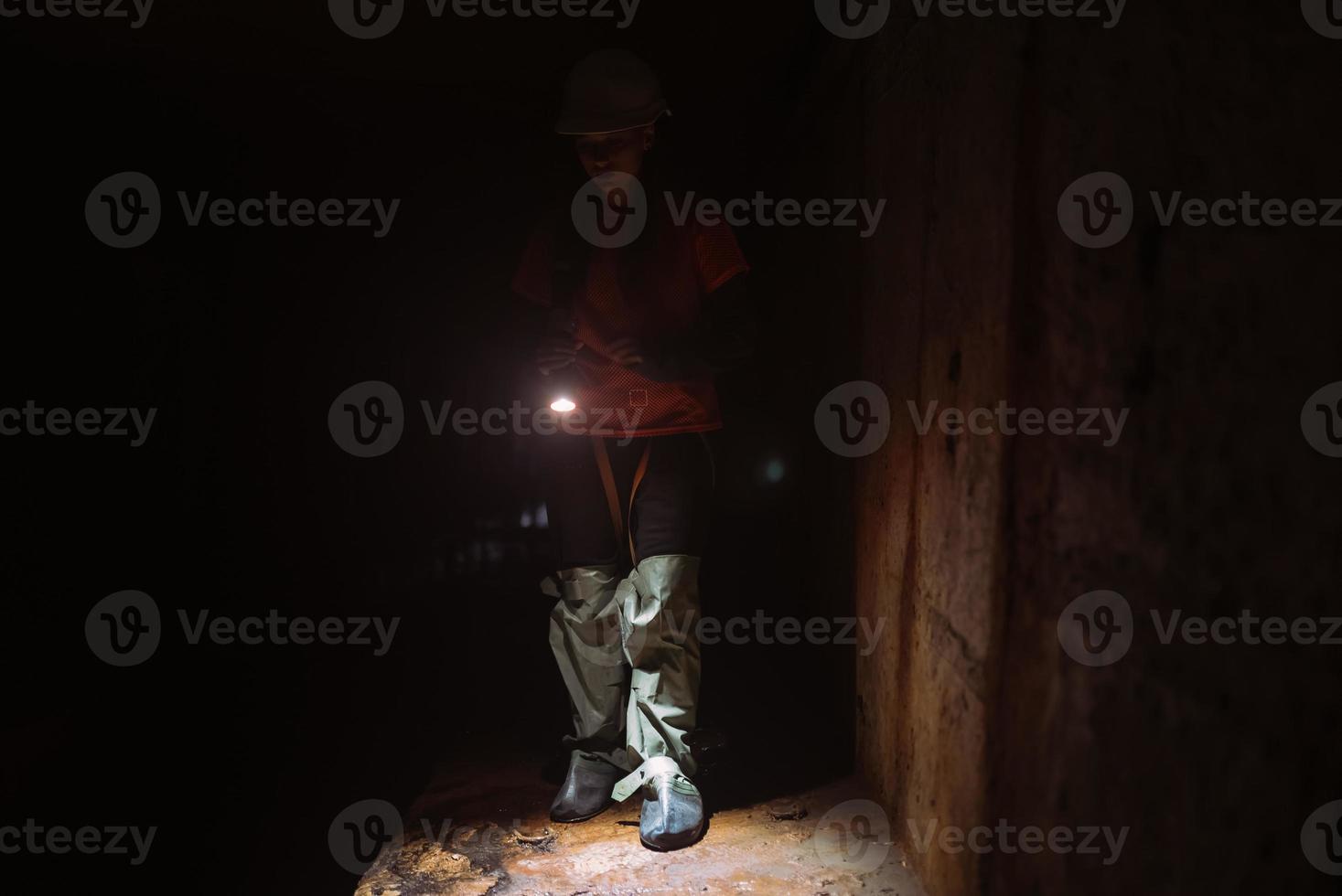 kvinna grävare med ficklampa utforskar de tunnel foto