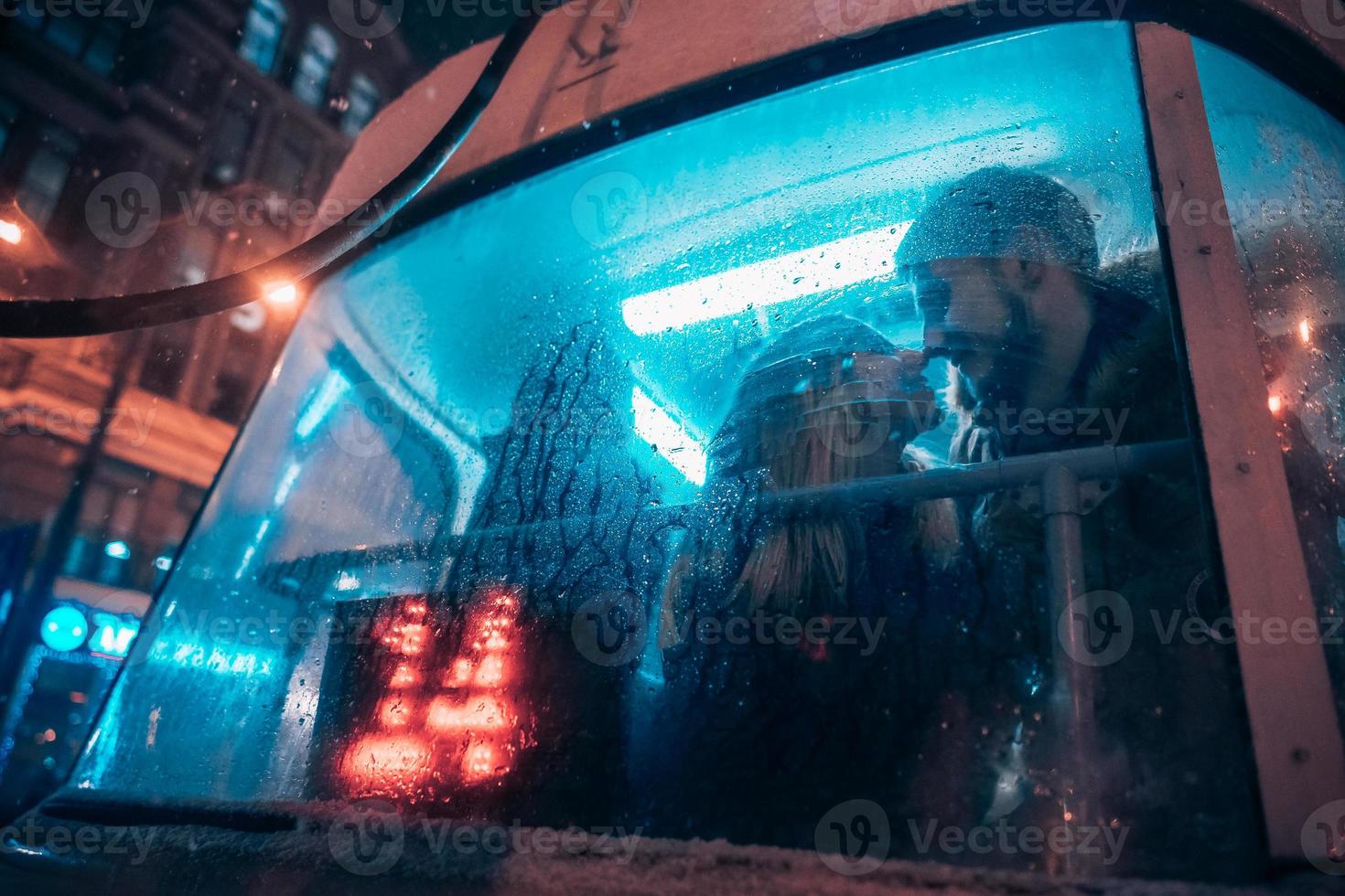de kille och de flicka kyss på de spårvagn Bakom de dimma glas foto