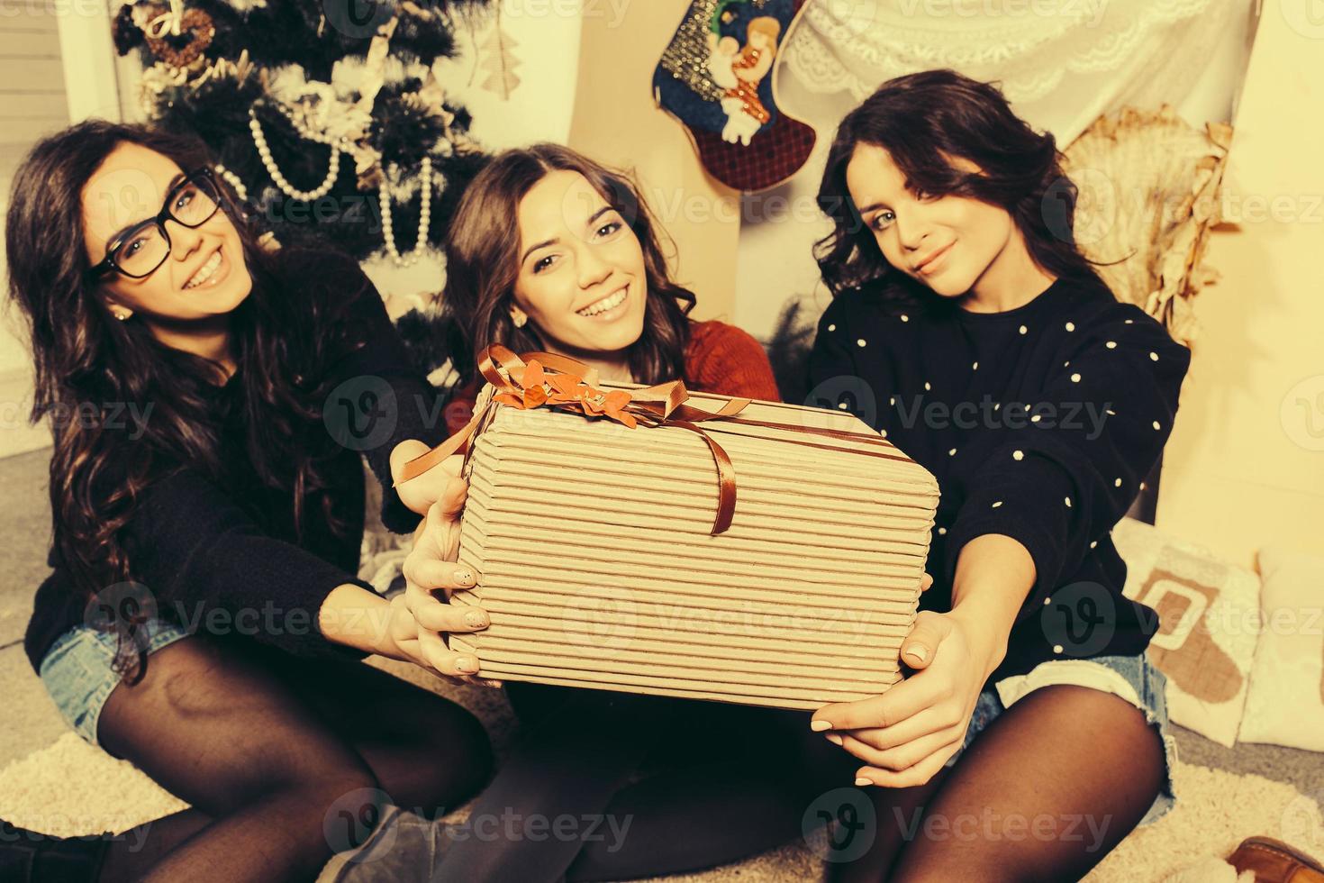 skön flicka visar jul gåvor direkt in i de kamera. dekorativ årgång lägenhet. foto