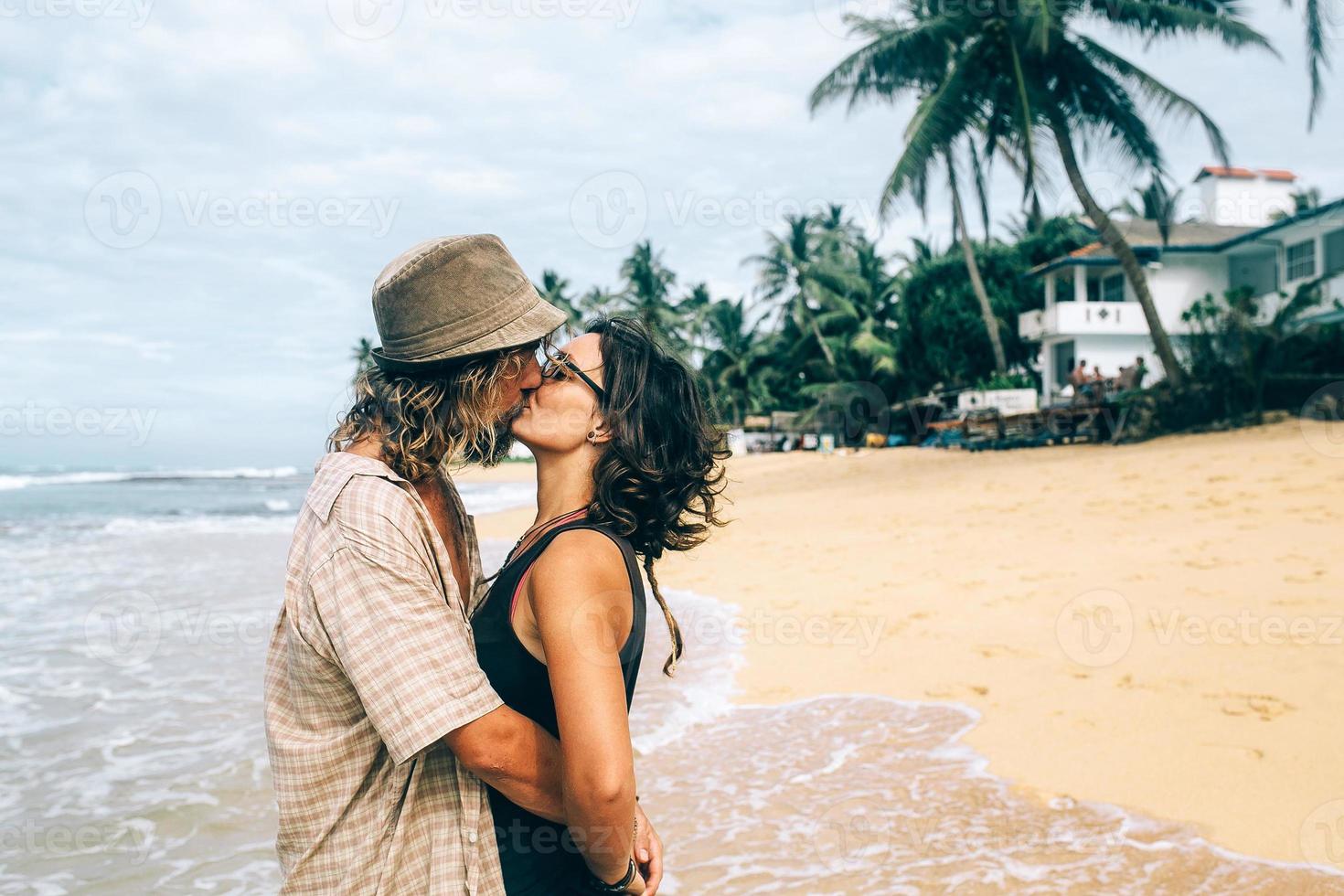 en kille och en flicka är kissing på en strand foto