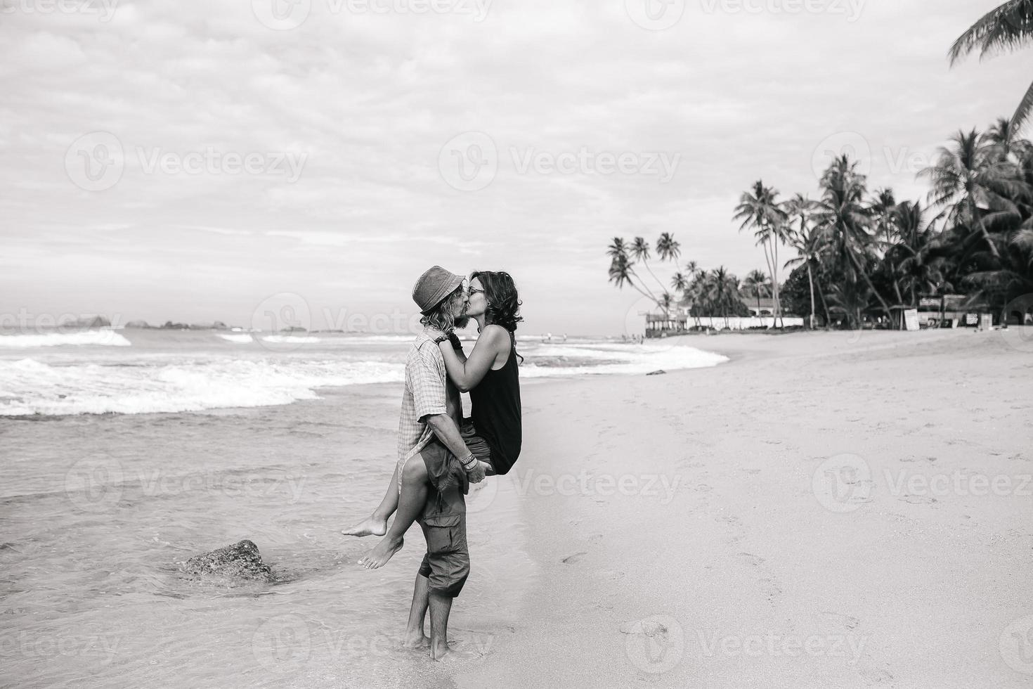 en kille och en flicka är kissing på en strand foto