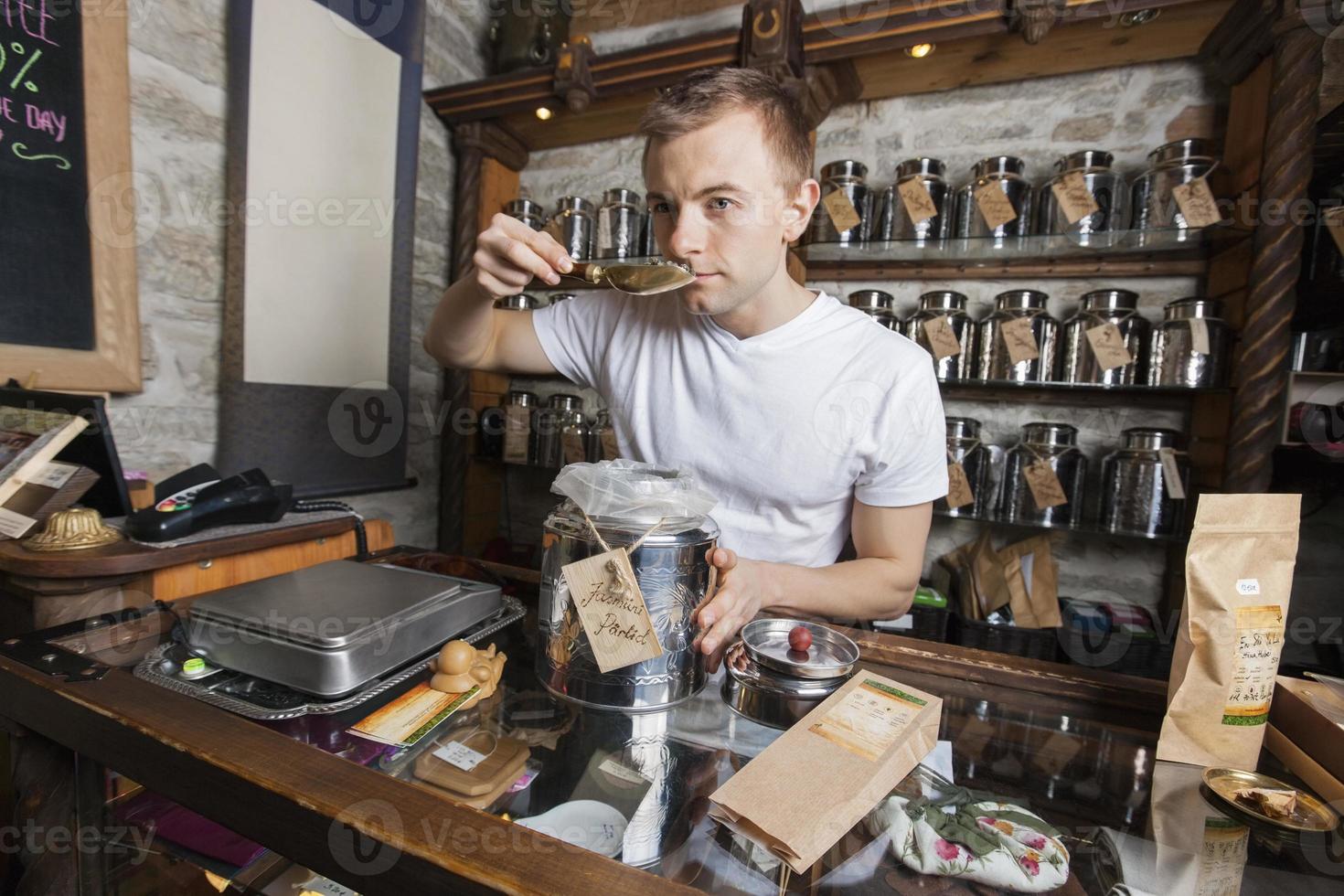 försäljare som luktar te i butiken foto