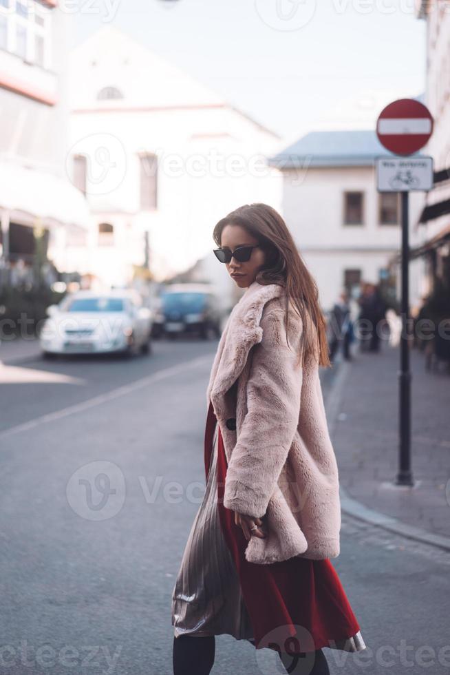 ung skön eleganta kvinna gående i rosa täcka foto
