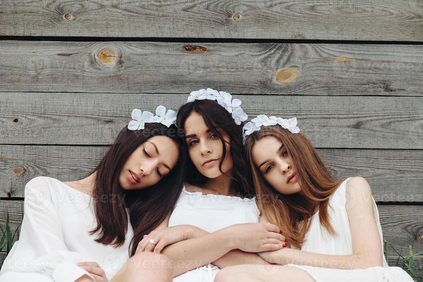 tre charmig flickor nära en trä- hus foto