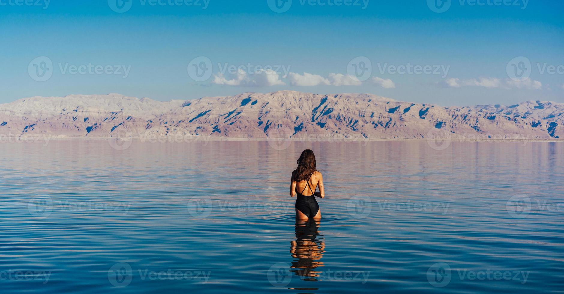 ung kvinna gående till död- hav, Israel foto