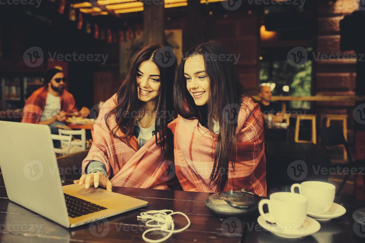 två flickor tittar på något i bärbar dator foto