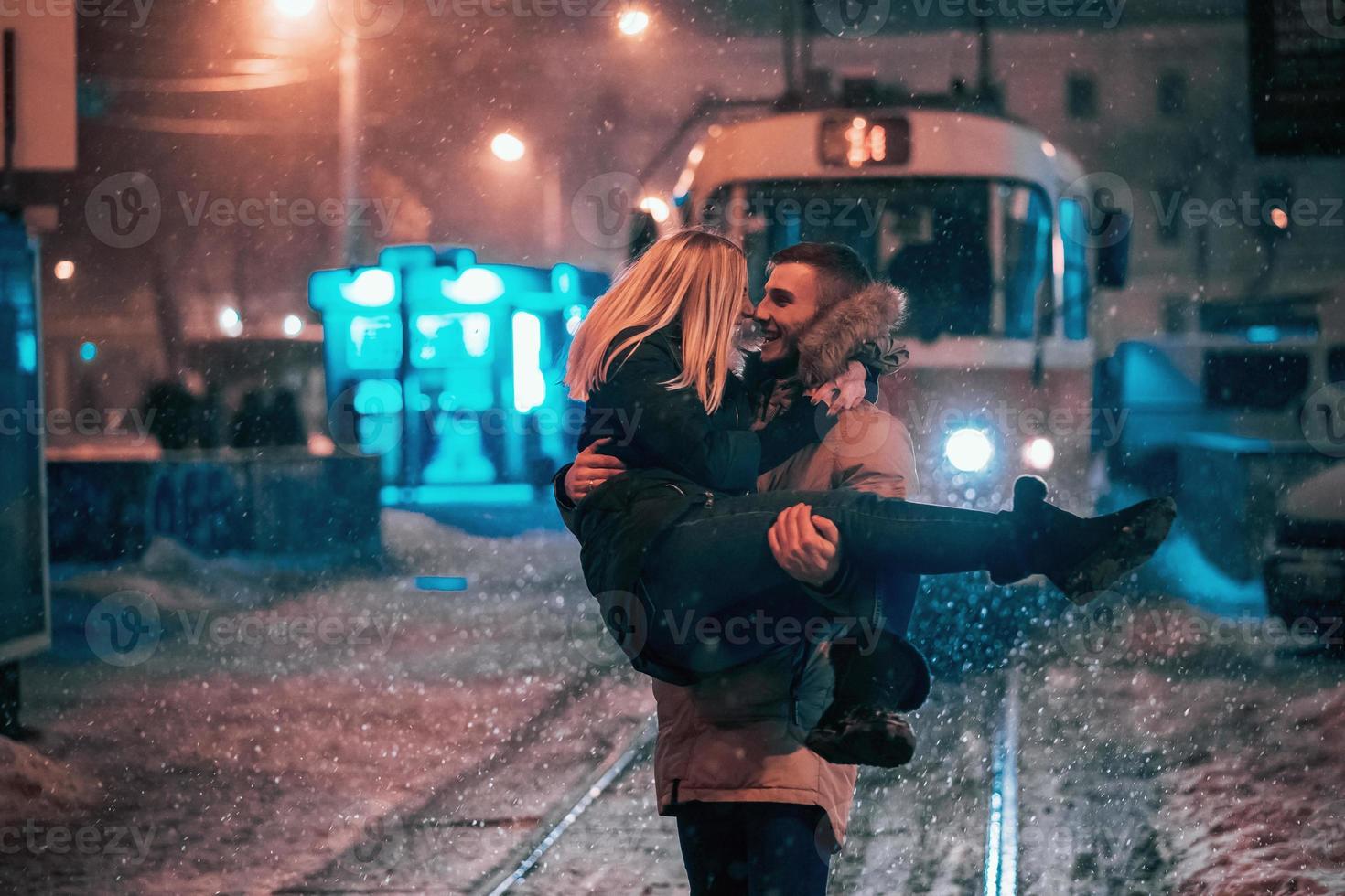 ung vuxen par på de snötäckt spårvagn linje foto